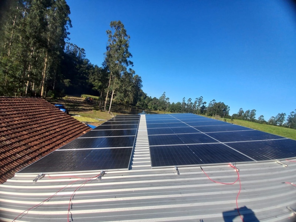 Placas solares no telhado metálico de um galpão rural em Paulo Frontin
