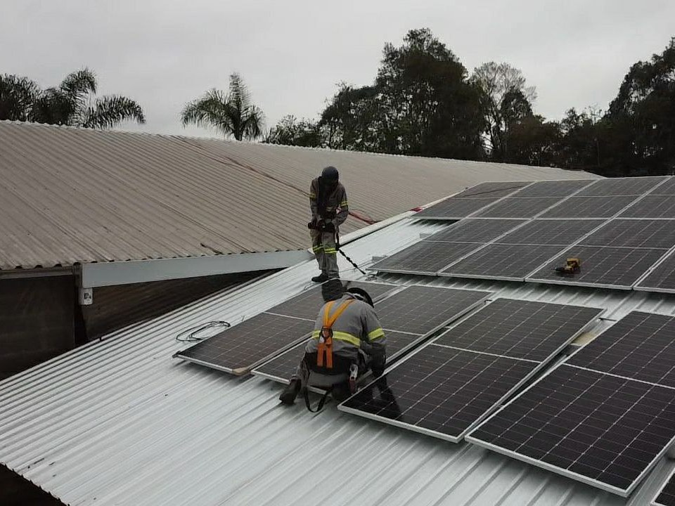 Instaladores da Perfect com cinto de segurança sobre um telhado metálico