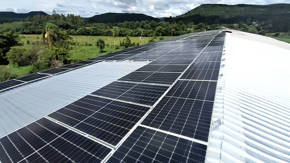 Placas solares no telhado metálico de um comércio em Porto Vitória